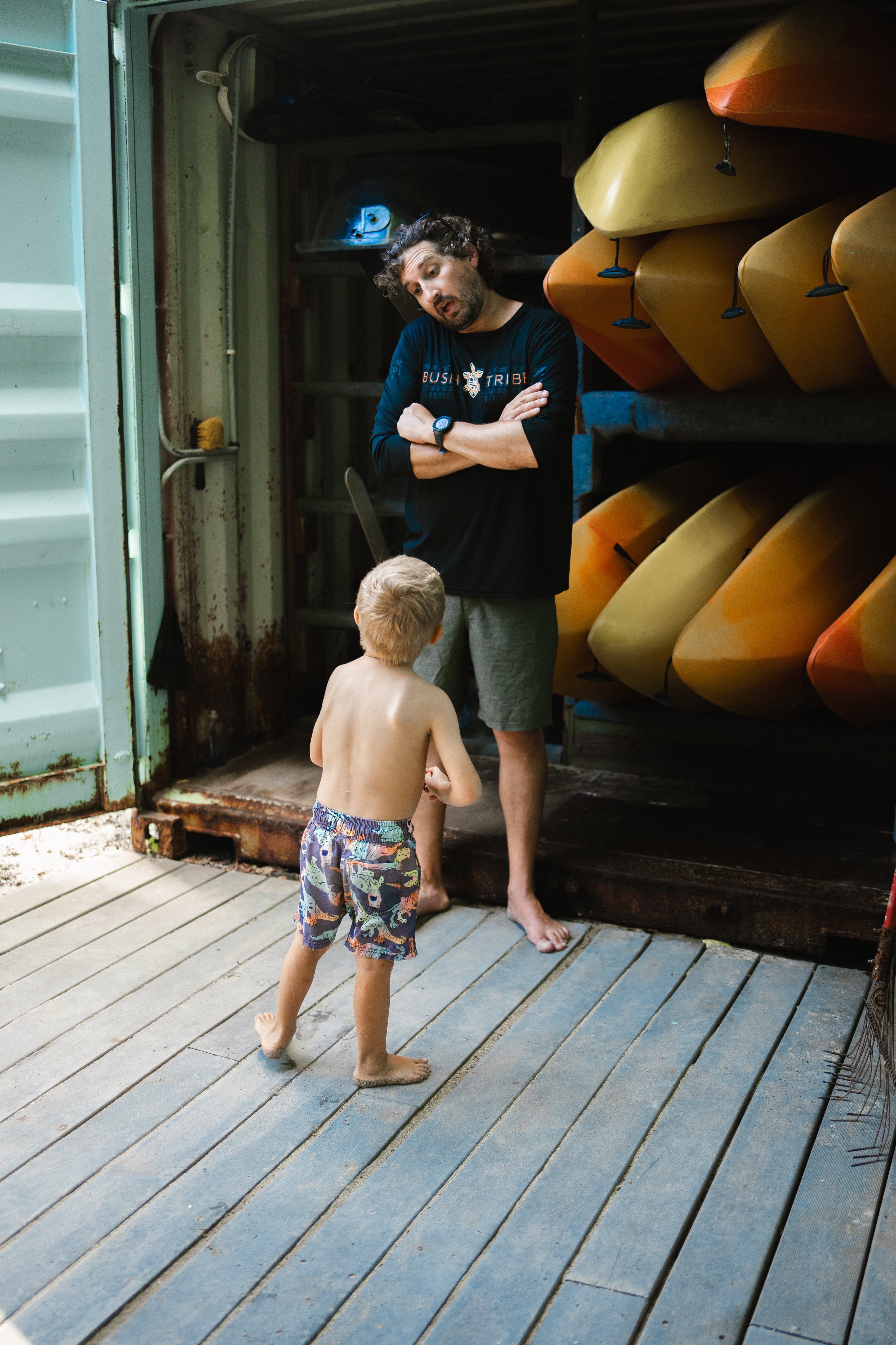 BushTribe guide talking with a young guest beside kayaks on St. Croix